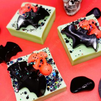 Handmade Halloween wax melts with spooky bat designs, decorated with black and holographic glitter. Perfect for Halloween home fragrance and autumn décor